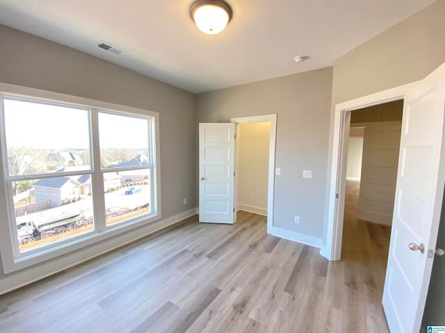 unfurnished bedroom with a closet and light hardwood / wood-style floors