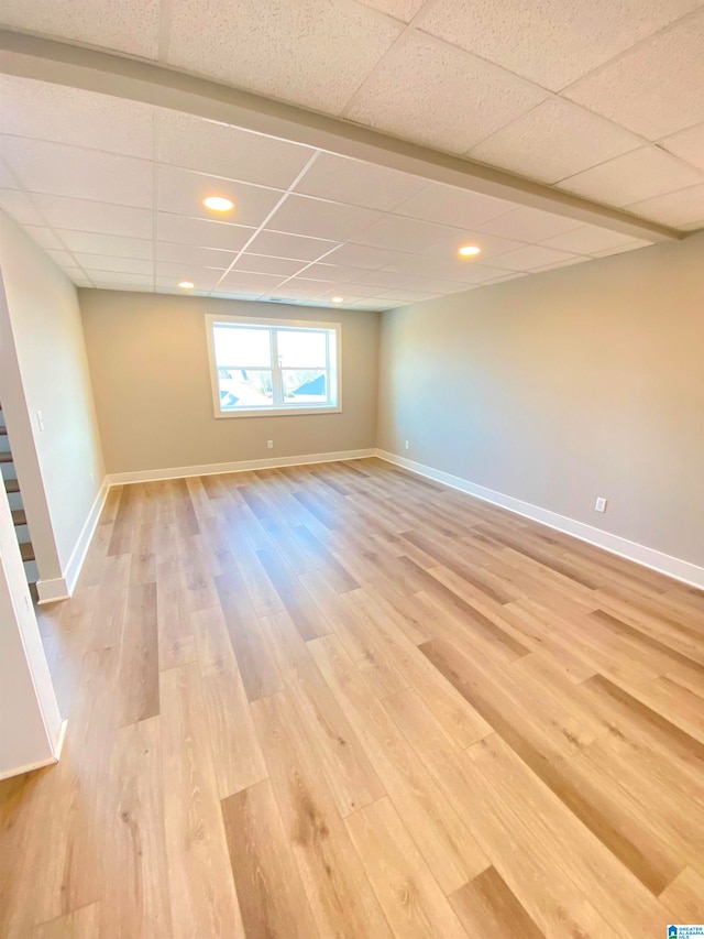 empty room featuring light hardwood / wood-style flooring and a paneled ceiling