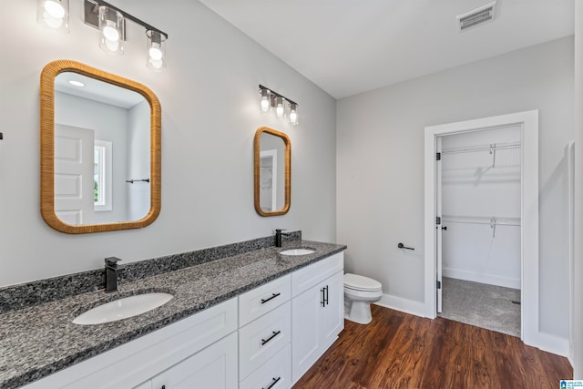 bathroom with hardwood / wood-style floors, toilet, and vanity