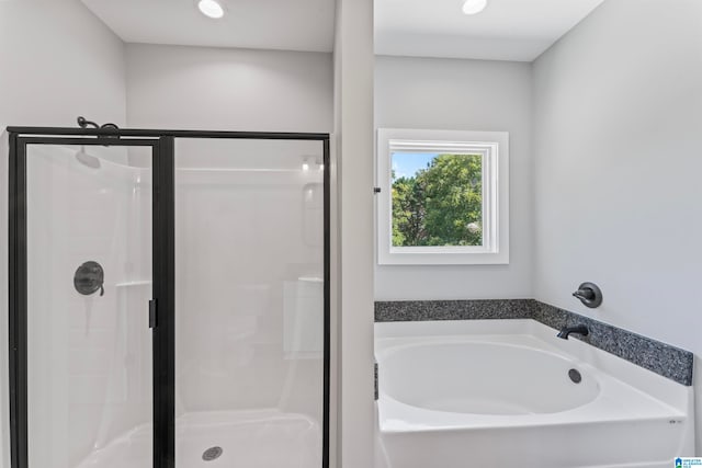 bathroom featuring separate shower and tub