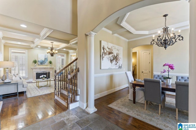 dining room featuring decorative columns, coffered ceiling, dark wood-type flooring, and a chandelier