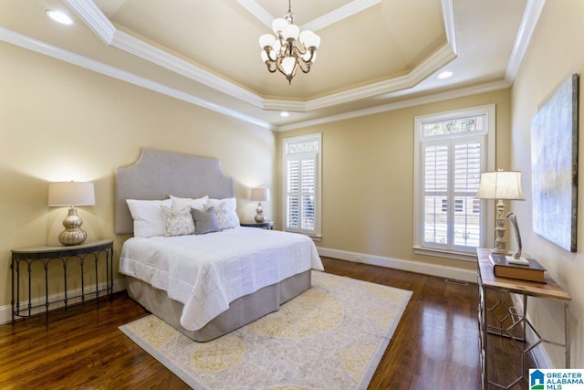 bedroom with a chandelier, dark hardwood / wood-style floors, a tray ceiling, and multiple windows