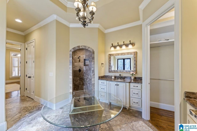 bathroom with a chandelier, vanity, ornamental molding, walk in shower, and tile floors