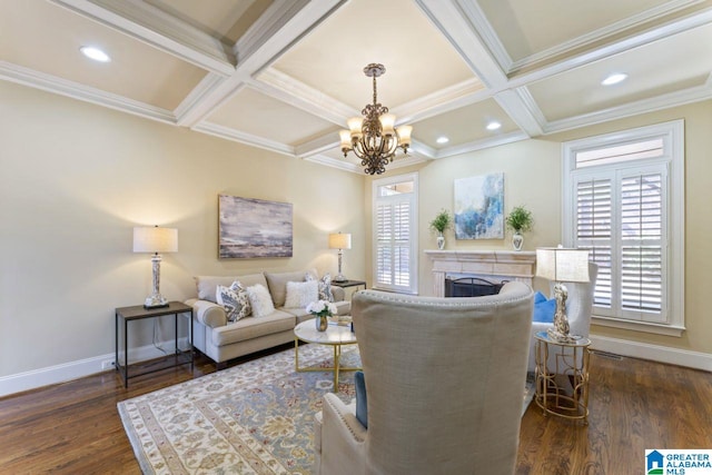 living room featuring dark wood-type flooring, beamed ceiling, coffered ceiling, a chandelier, and ornamental molding