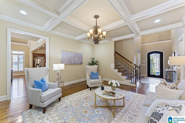 living room with hardwood / wood-style floors, coffered ceiling, a notable chandelier, and a wealth of natural light