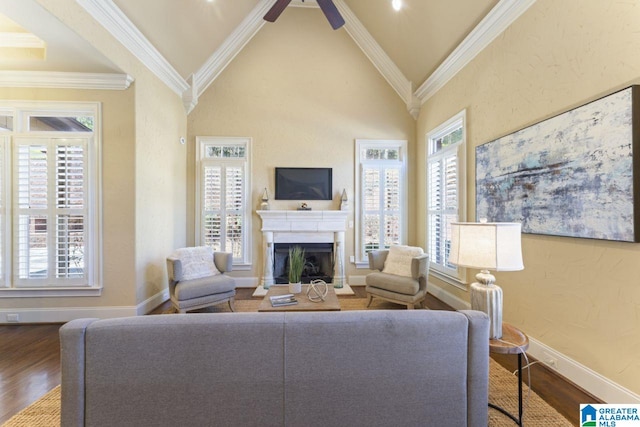 living room with ceiling fan, ornamental molding, a healthy amount of sunlight, and wood-type flooring