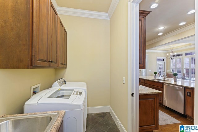 laundry area with an inviting chandelier, cabinets, sink, separate washer and dryer, and crown molding