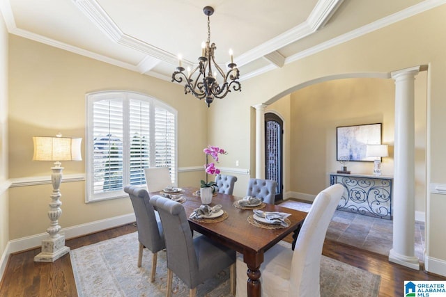 dining room with a notable chandelier, a raised ceiling, and dark wood-type flooring