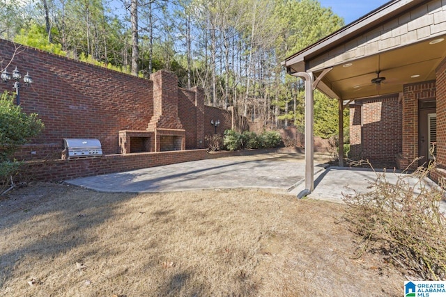 view of yard featuring ceiling fan and a patio