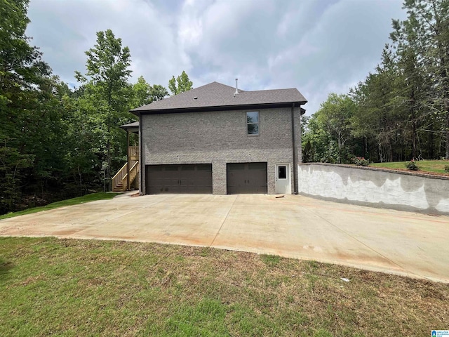 view of side of property with a lawn and a garage