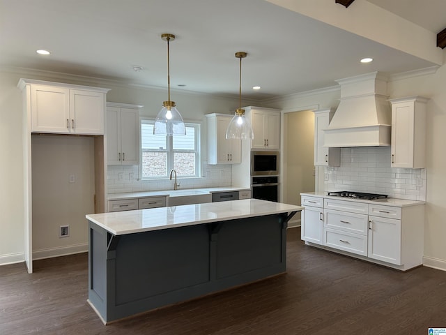 kitchen with a center island, stainless steel appliances, white cabinetry, and custom exhaust hood