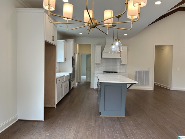 kitchen featuring white cabinets, dark wood-type flooring, and decorative light fixtures