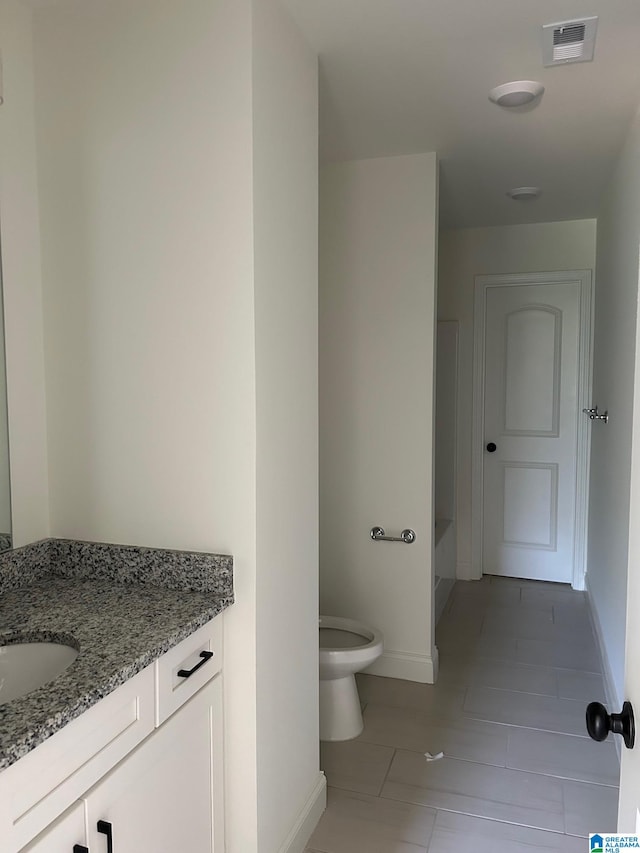 bathroom with tile patterned flooring, vanity, and toilet