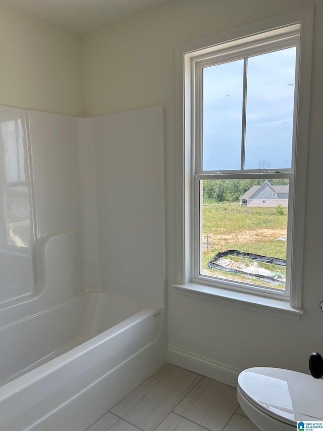 bathroom with plus walk in shower, tile patterned flooring, and toilet