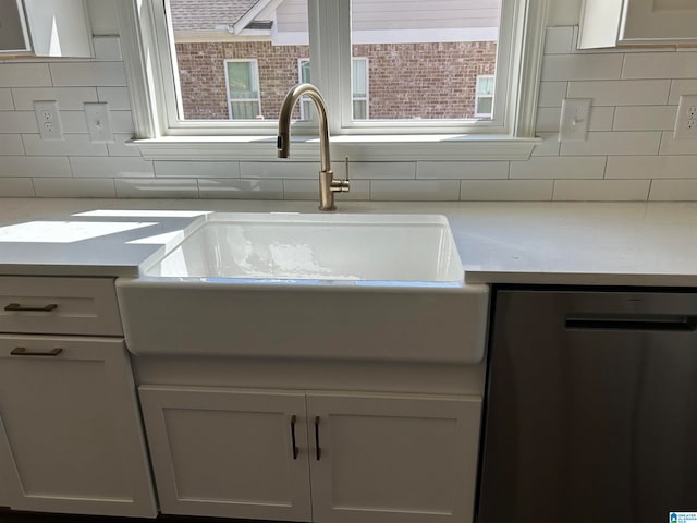 interior details featuring dishwasher, tasteful backsplash, white cabinets, and sink