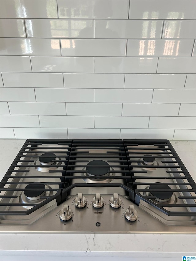 interior details featuring stainless steel gas stovetop and light stone countertops