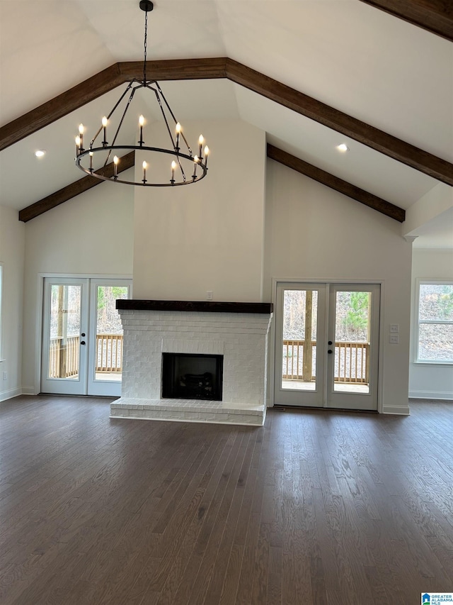 unfurnished living room featuring dark hardwood / wood-style flooring, french doors, beamed ceiling, and a brick fireplace