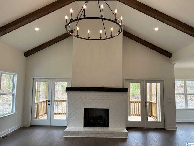 unfurnished living room with plenty of natural light, dark wood-type flooring, and french doors