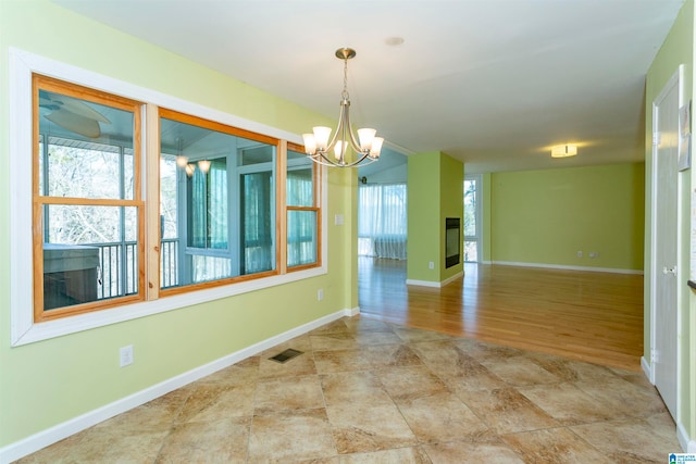 spare room with an inviting chandelier and light wood-type flooring