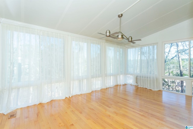 spare room with ceiling fan, vaulted ceiling with beams, and light hardwood / wood-style floors