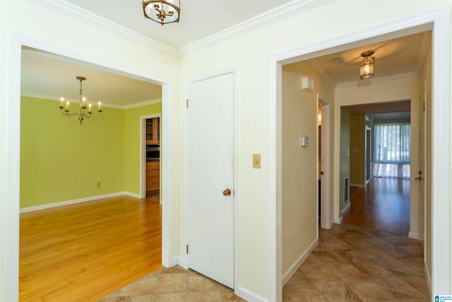 corridor featuring an inviting chandelier, wood-type flooring, and crown molding