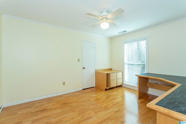 unfurnished office featuring crown molding, ceiling fan, and light wood-type flooring