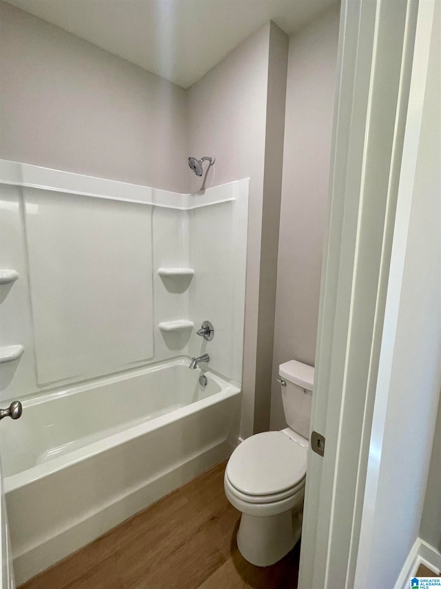 bathroom featuring shower / washtub combination, wood-type flooring, and toilet