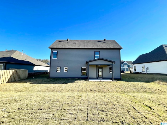 rear view of property featuring a yard and a patio area