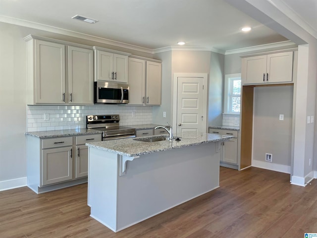 kitchen featuring sink, a kitchen island with sink, hardwood / wood-style floors, and stainless steel appliances