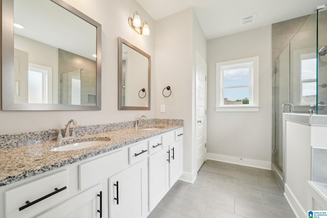 bathroom featuring tile patterned flooring, an enclosed shower, and vanity