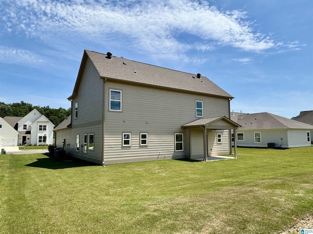 rear view of house with a lawn, cooling unit, and a patio