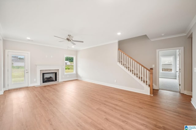 unfurnished living room featuring ceiling fan, light wood-type flooring, and crown molding