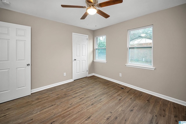 empty room featuring dark hardwood / wood-style flooring and ceiling fan