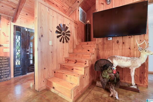 stairs featuring wooden ceiling, wooden walls, light tile floors, and lofted ceiling