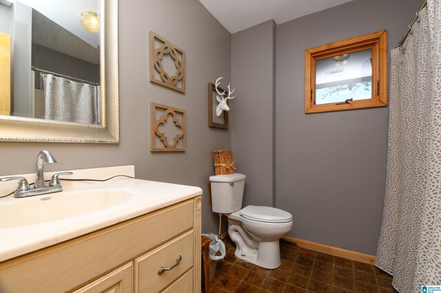 bathroom featuring tile flooring, vanity, and toilet