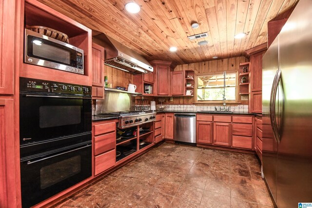 kitchen featuring wall chimney range hood, appliances with stainless steel finishes, wooden ceiling, tasteful backsplash, and dark tile floors