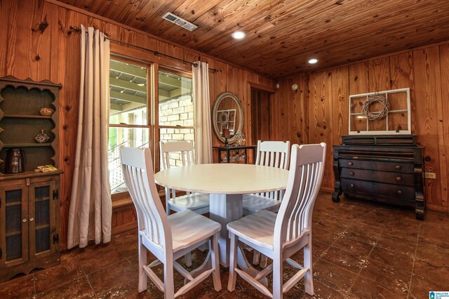 tiled dining area featuring wood walls and wooden ceiling