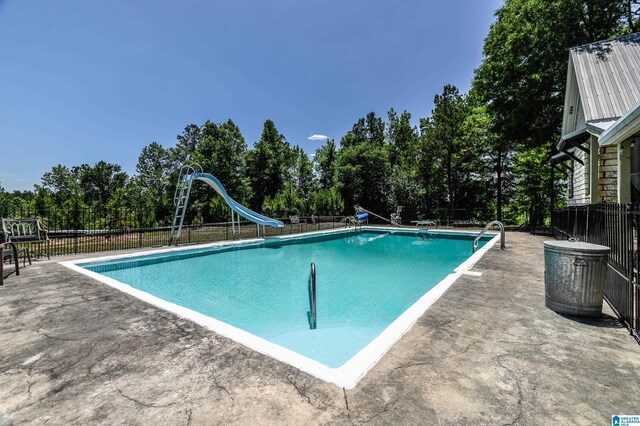 view of pool featuring a water slide and a patio