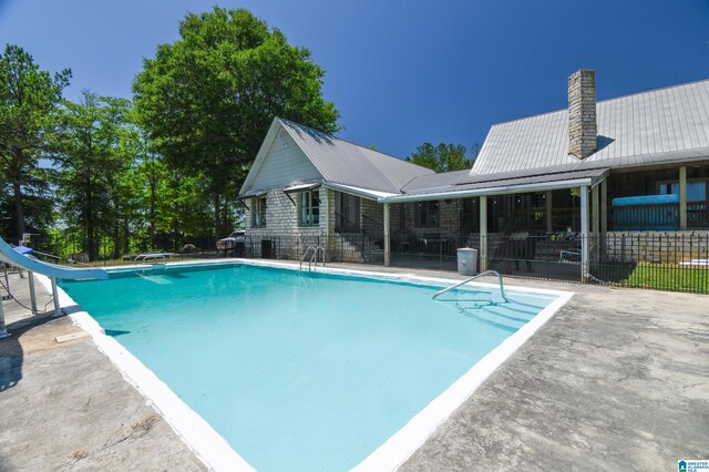 view of pool with a patio area and a water slide