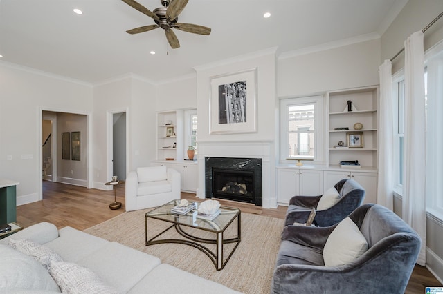 living area with ceiling fan, wood finished floors, and a high end fireplace