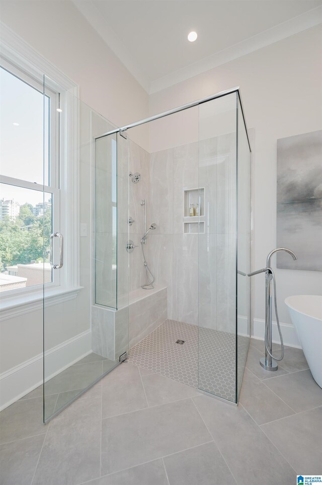 bathroom featuring a freestanding tub, a tile shower, and tile patterned floors