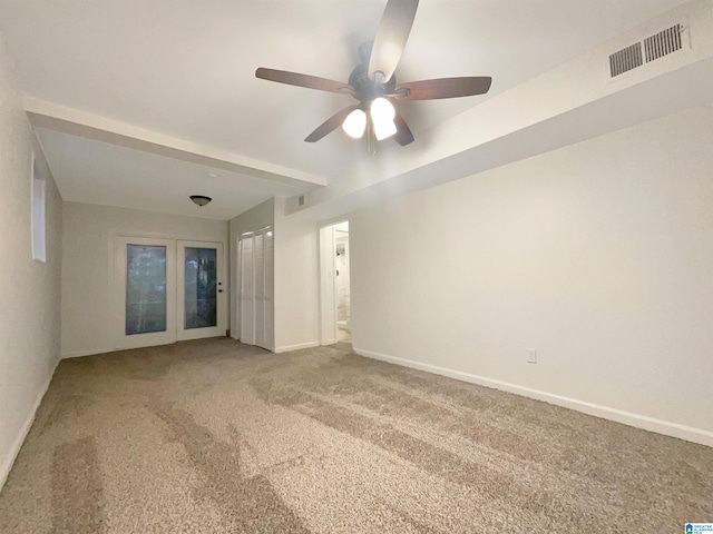 empty room with ceiling fan, french doors, and light carpet