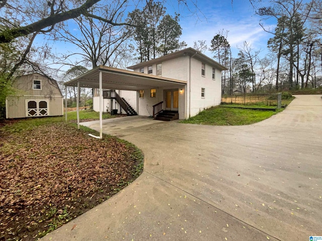 rear view of property featuring a carport and an outdoor structure