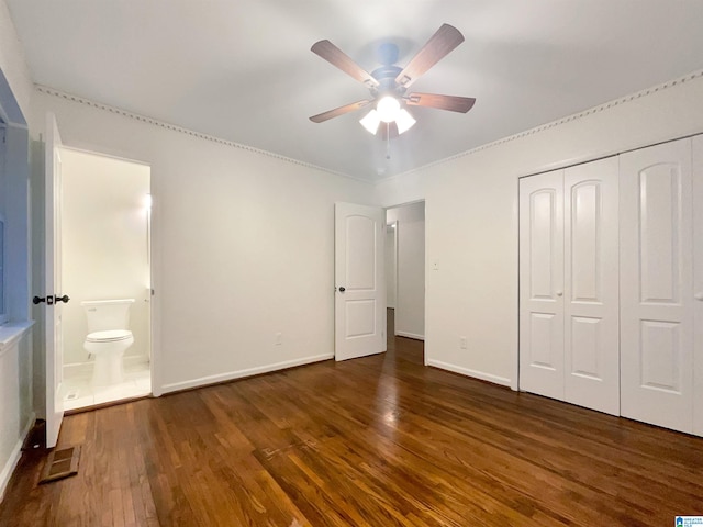 unfurnished bedroom with ceiling fan, a closet, ensuite bathroom, and dark hardwood / wood-style floors