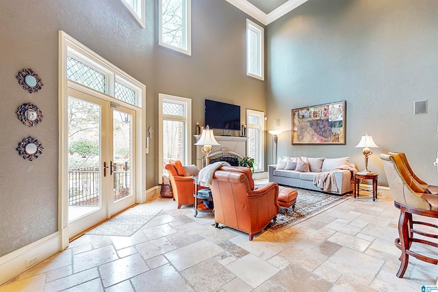 tiled living room with french doors, a towering ceiling, and crown molding