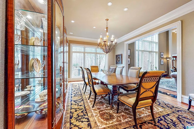 dining area featuring hardwood / wood-style flooring, a chandelier, and ornamental molding