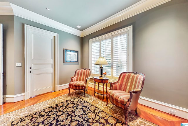 living area with hardwood / wood-style floors and crown molding