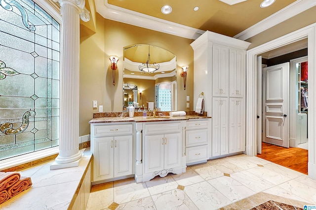 bathroom with decorative columns, large vanity, ornamental molding, tile flooring, and a raised ceiling