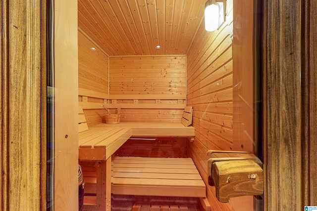 view of sauna / steam room featuring wooden walls and wooden ceiling