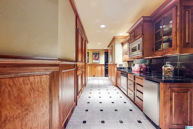 kitchen featuring appliances with stainless steel finishes, tasteful backsplash, sink, and light tile floors